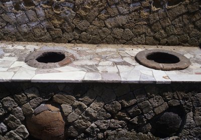 Resti restaurati di un thermopolium (snack bar) con ciotole incassate nel bancone da Roman